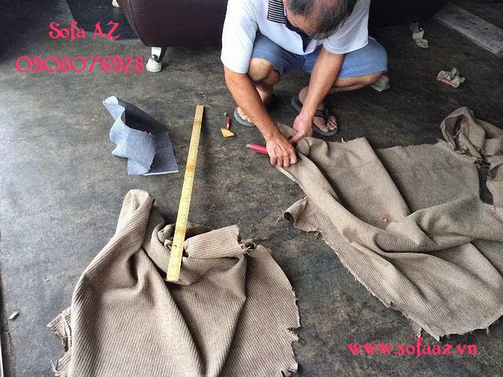 Thợ sofa cắt bộ áo cũ của bộ ghế ra theo từng mãnh để lấy mẫu trước quá trình bọc lại ghế sofa